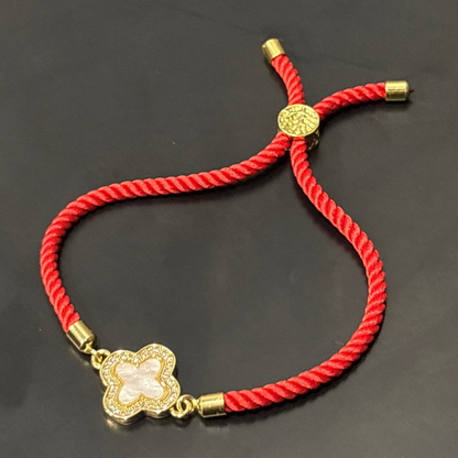 Red bracelet with a gold clasp on a dark surface