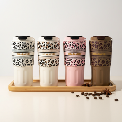 Set of four patterned tumblers on a wooden tray with a white background