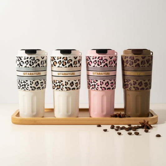 Set of four patterned tumblers on a wooden tray with a white background